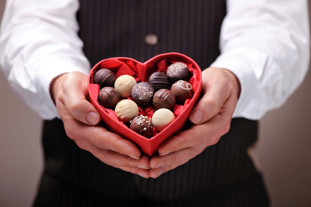 man holding heart shaped box of chocolates