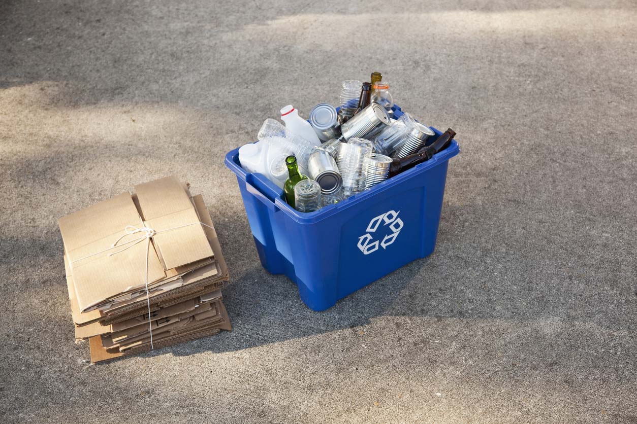 recycling bin and broken down cardboard boxes on street