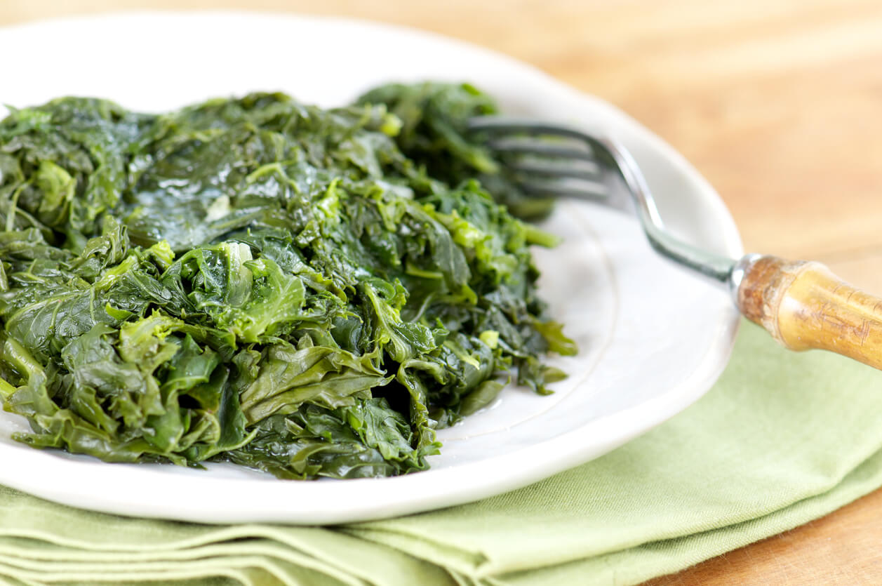 a plate of southern style braised greens next to a fork