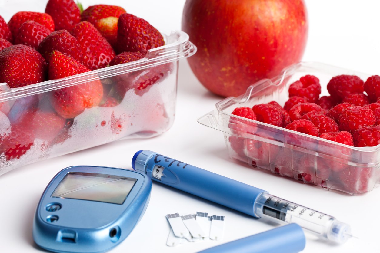 Инсулиновая ручка, тест-полоски и глюкометр с фруктами. Яблоко, клубника и малина.