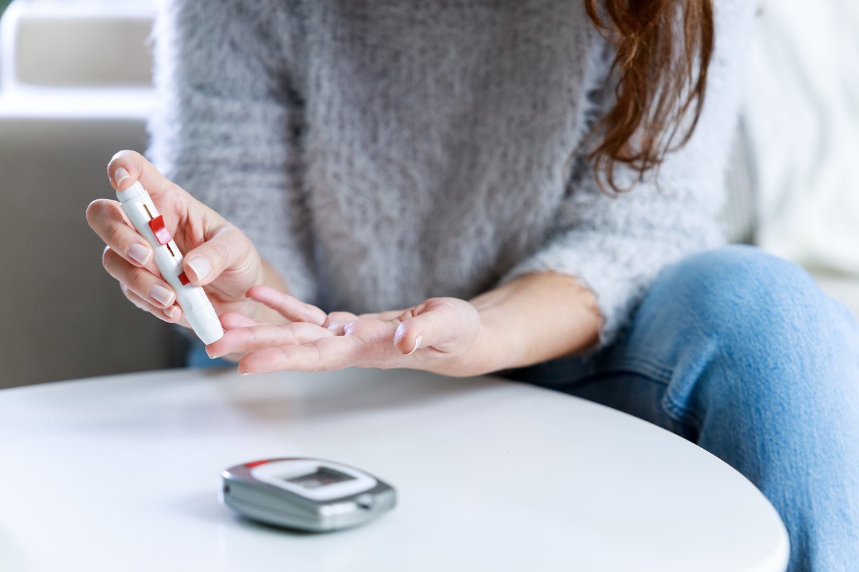 Woman using lancet on finger to check blood sugar level