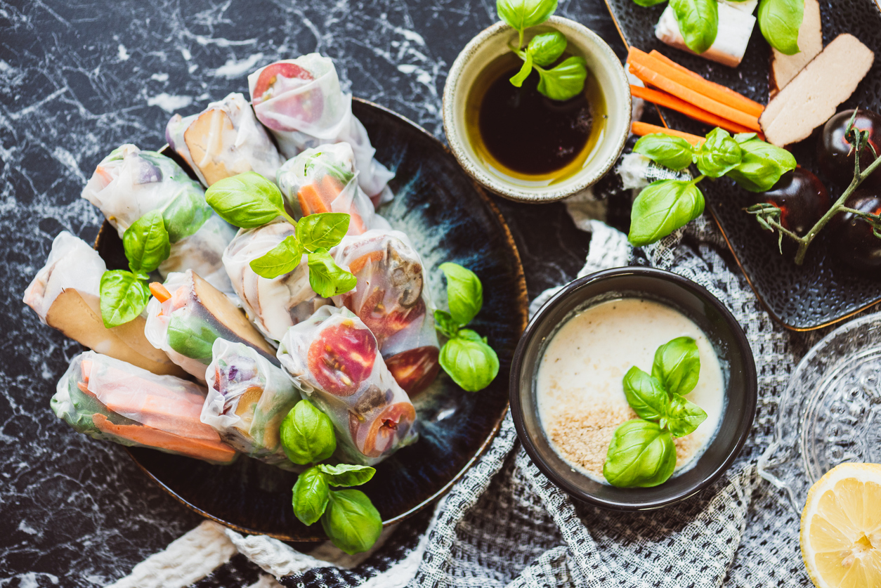 Homemade vegan summer rolls with tofu, carrots, basil leaves, tomatoes and tahini-yoghurt-dip