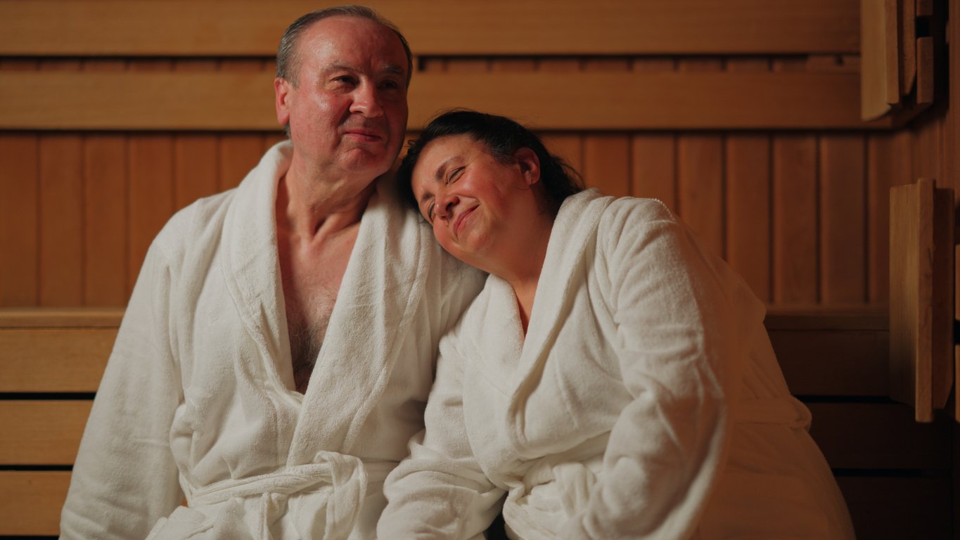 A senior adult couple is relaxing in sauna.