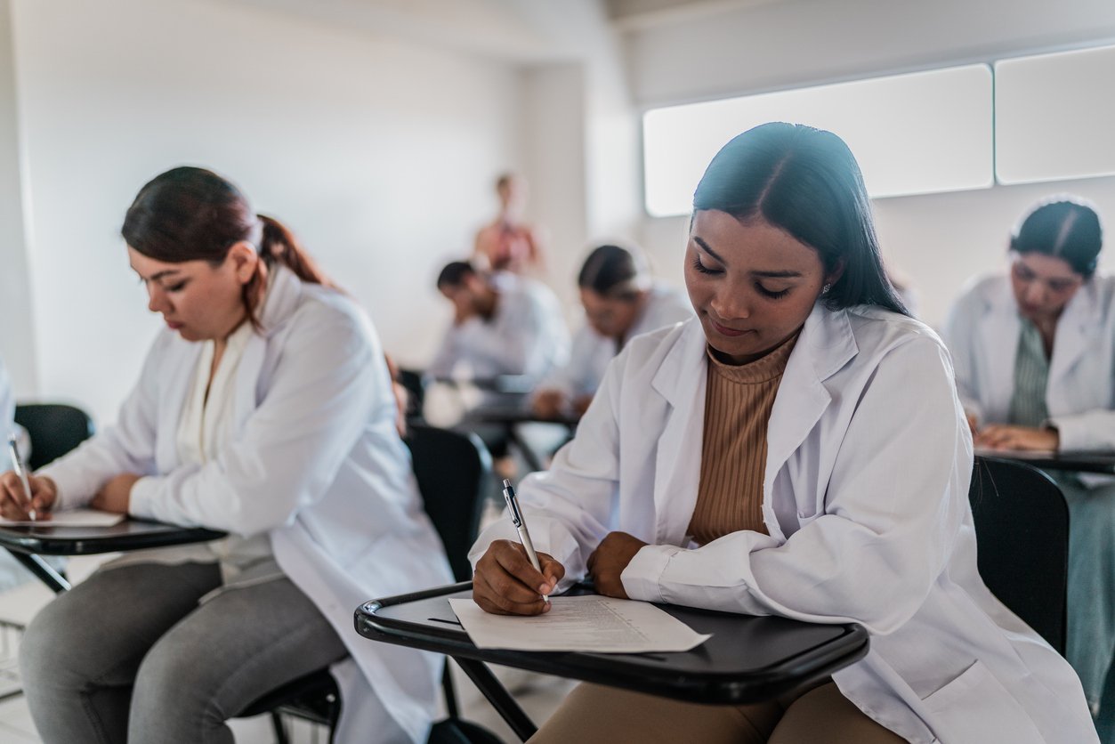 Young medical student woman doing educational exam on classroom at university