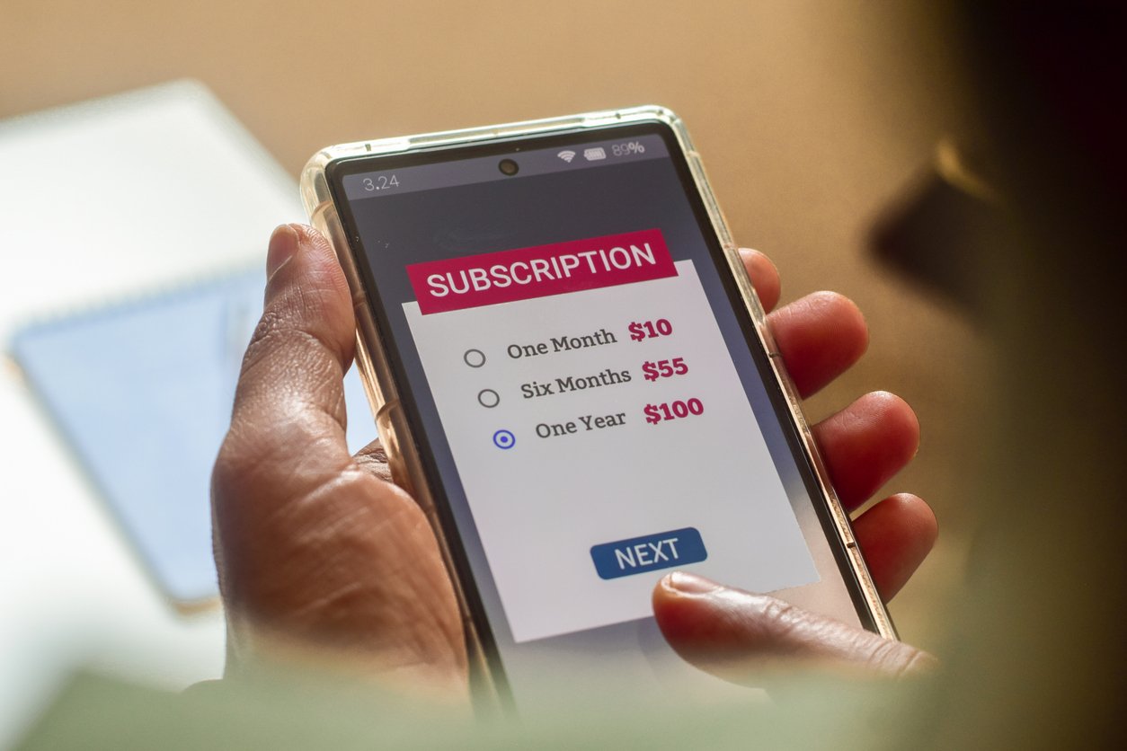 Man choosing a subscription plan for one year using mobile applications for newspaper or delivery or online streaming service.