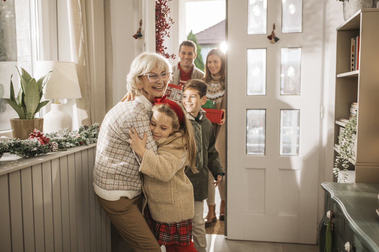 Grandparents welcoming grandchildren and parents for Christmas at home.