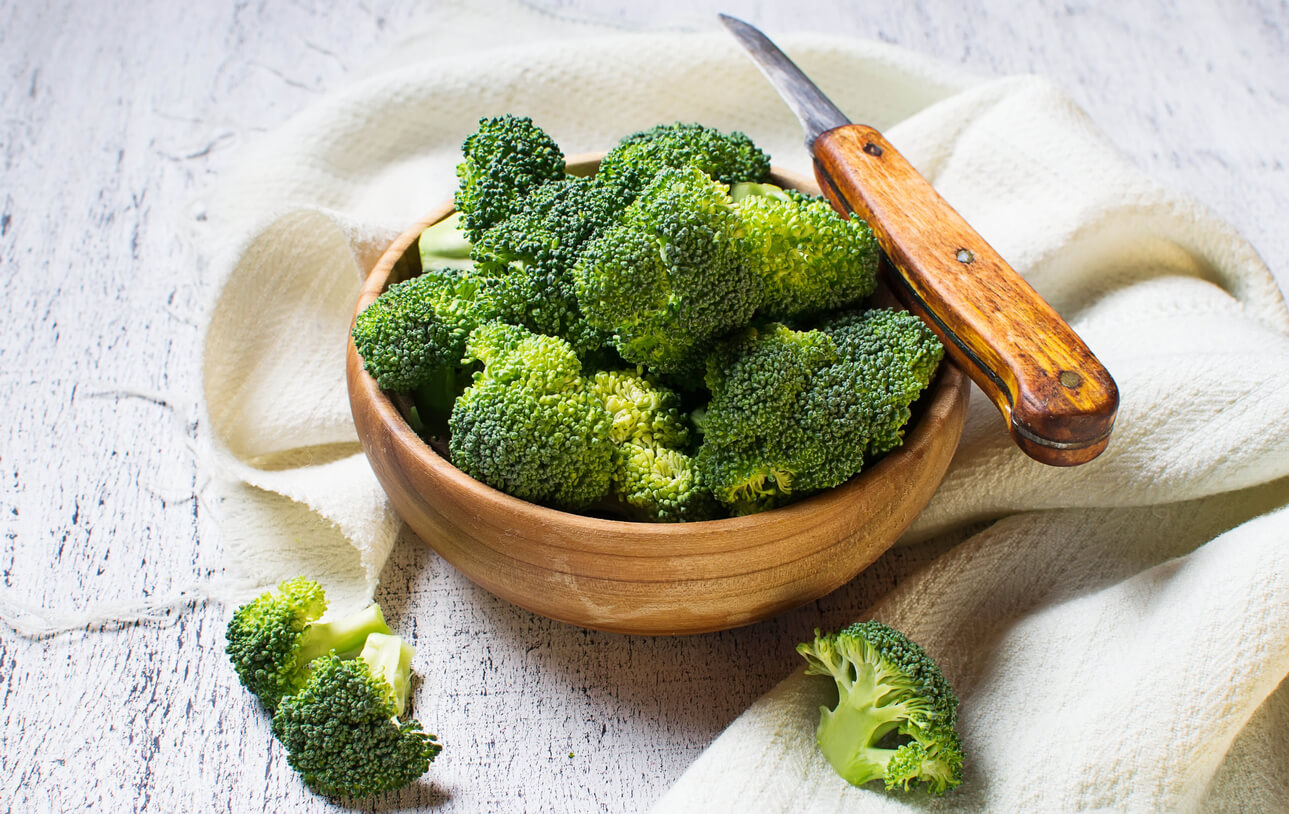 fresh sliced broccoli in wooden bowl