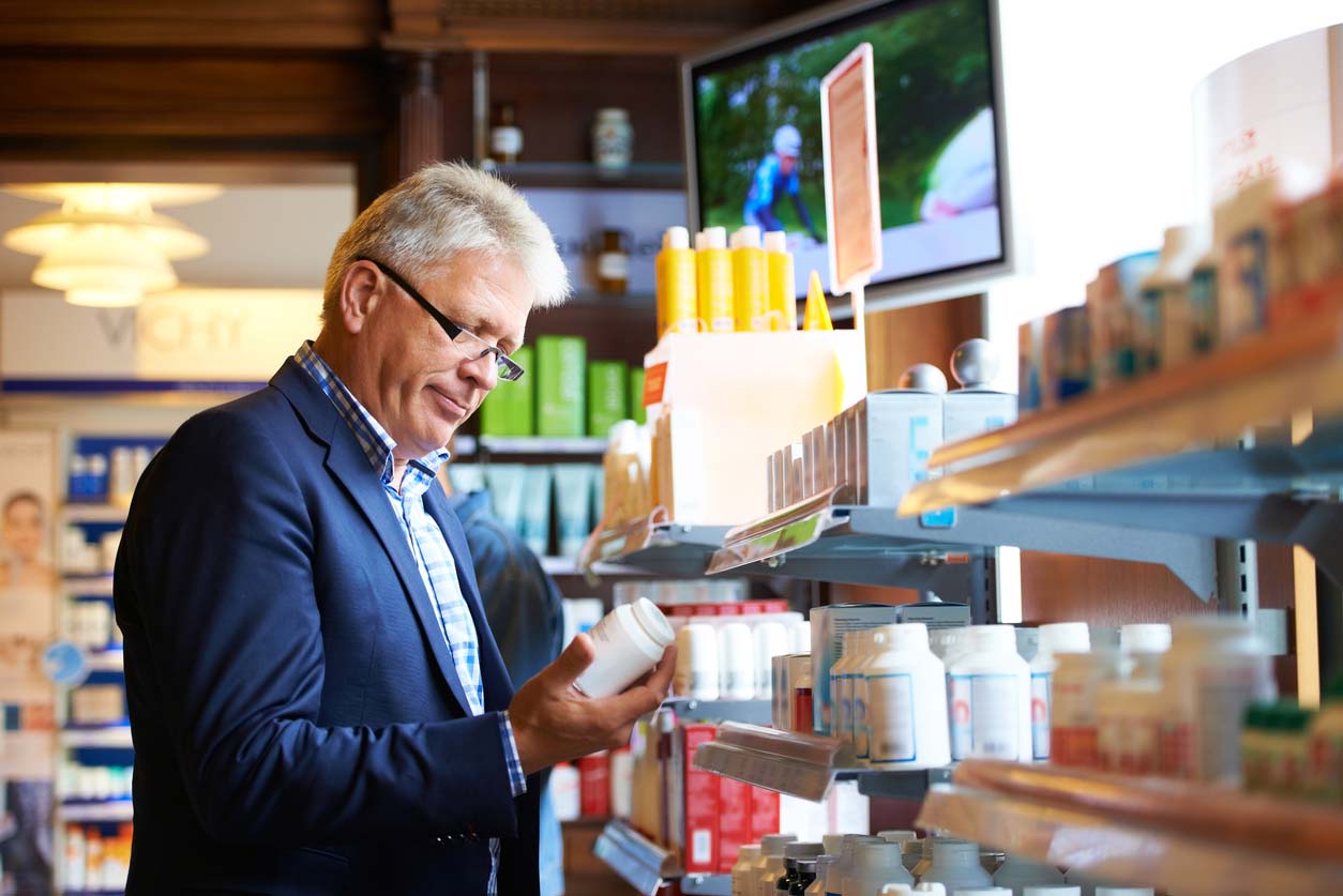 man reviewing supplements in supermarket