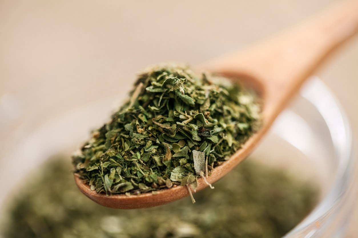 Dry Oregano in wood spoon - close up