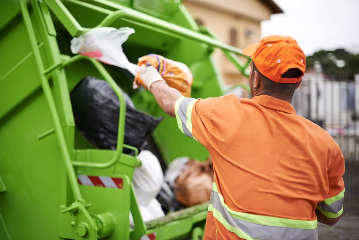 The pandemic waste problem is increasing - Man throwing trash in dump truck