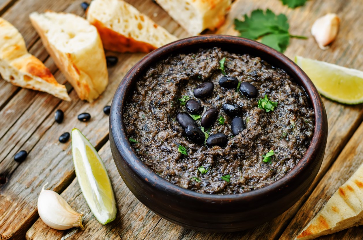 black beans hummus on a dark wood background. the toning. selective focus