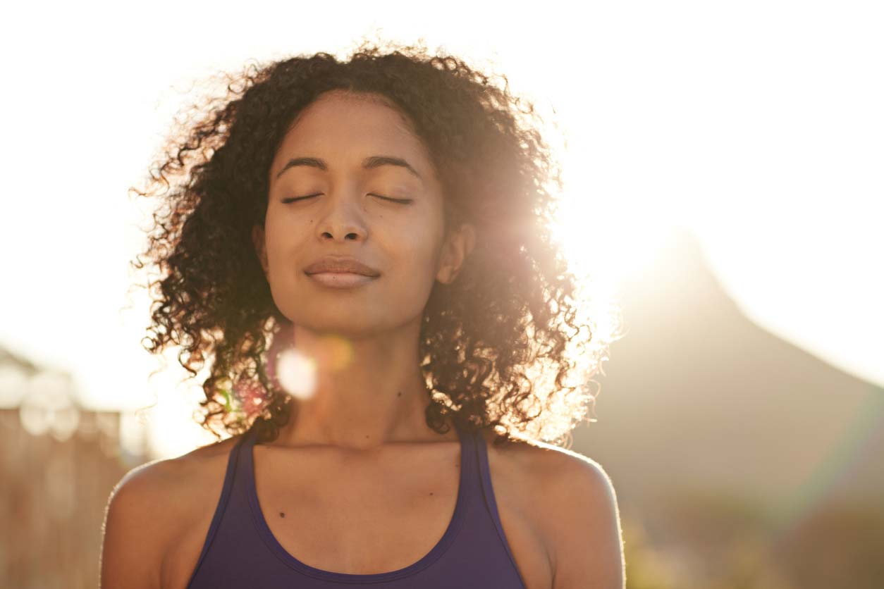 woman outdoors in sunshine with eyes closed