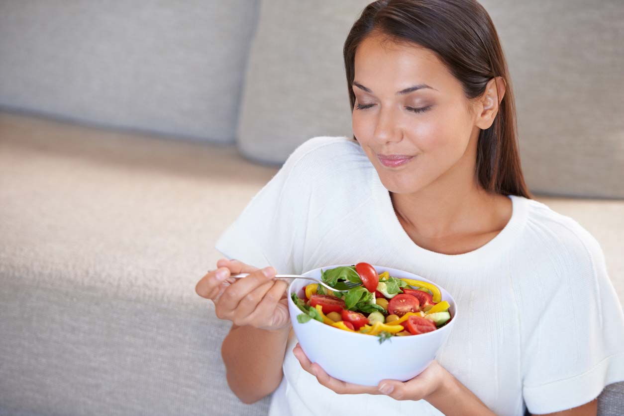 Woman practicing mindful eating and enjoying fresh salad