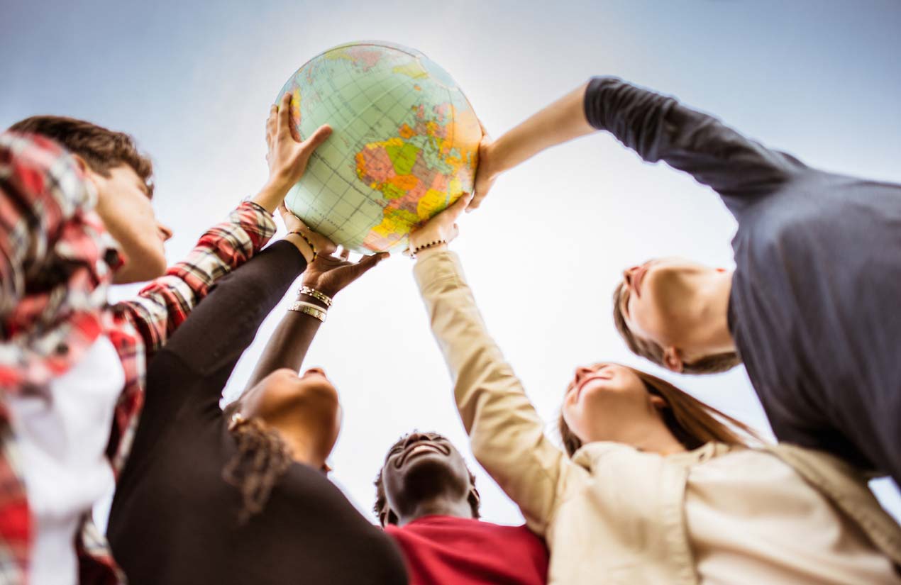 group holding globe above their heads