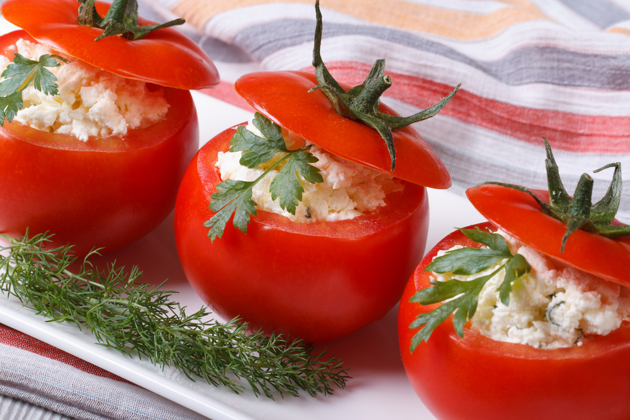 Fresh red tomatoes filled with soft cheese and herbs