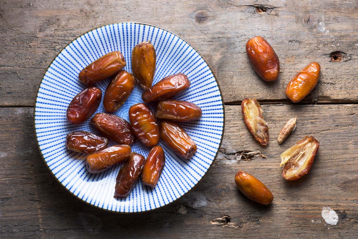 overhead view of dates on a plate and sliced open date