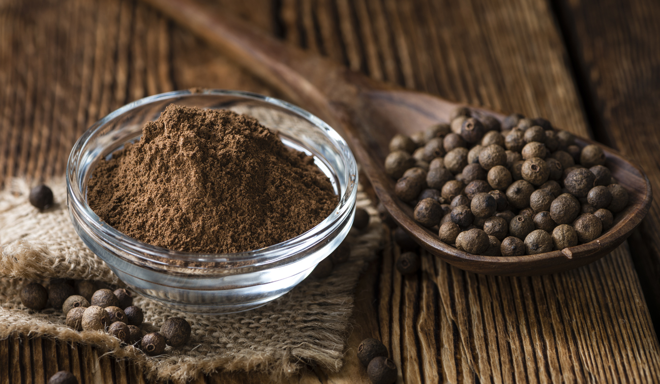 Old wooden table with Allspice powder (detailed close-up shot)