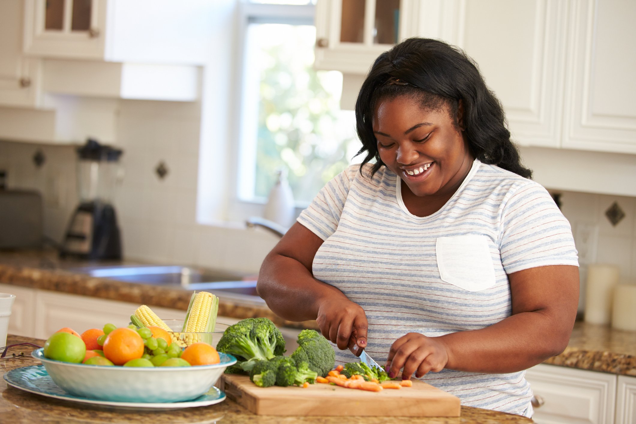 Woman Preparing Vegetables in Kitchen On Her Own Smiling