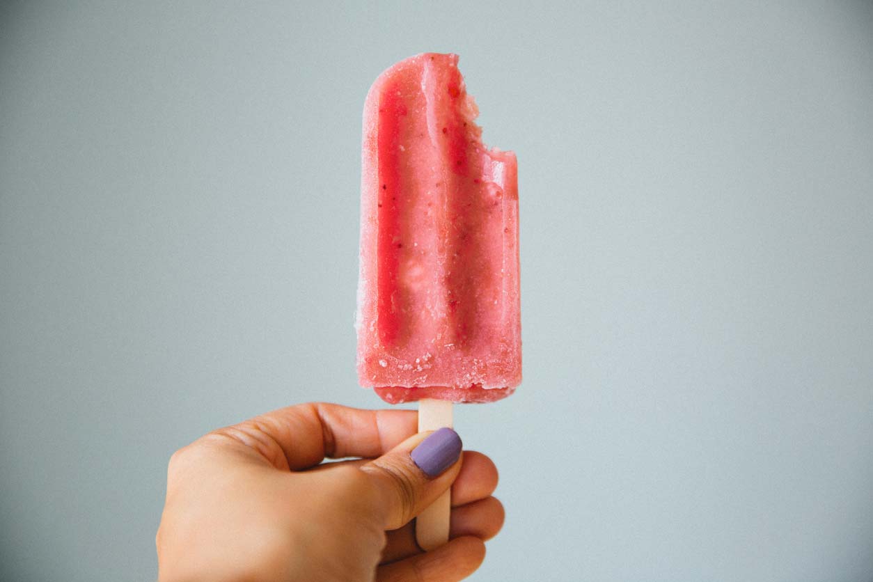 hand holding a strawberry popsicle