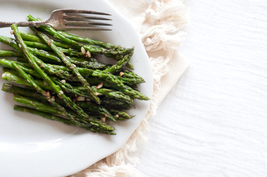 Asparagus on white plate with fork