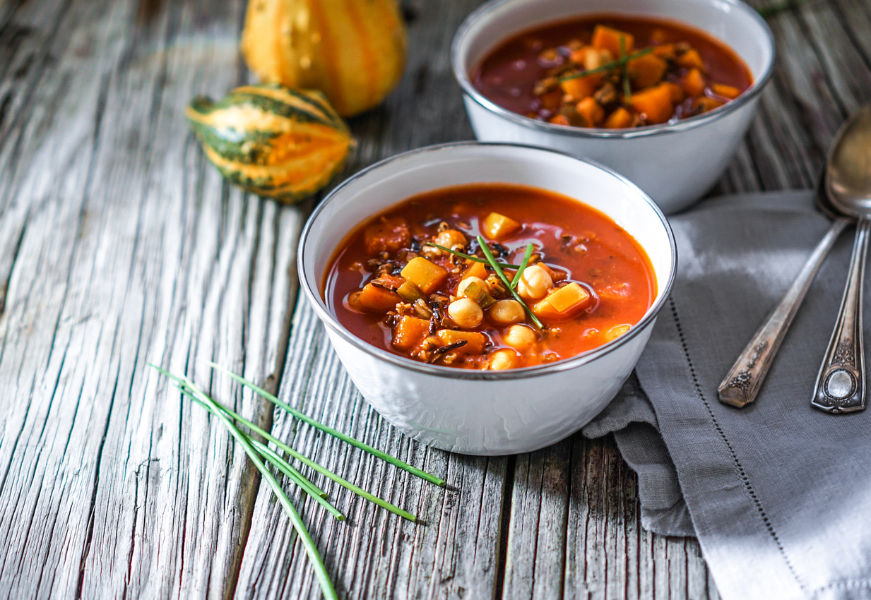 Vegetarian tasty spicy chili chick pea pumpkin wild rice soup pozole stew bowl on a wooden background