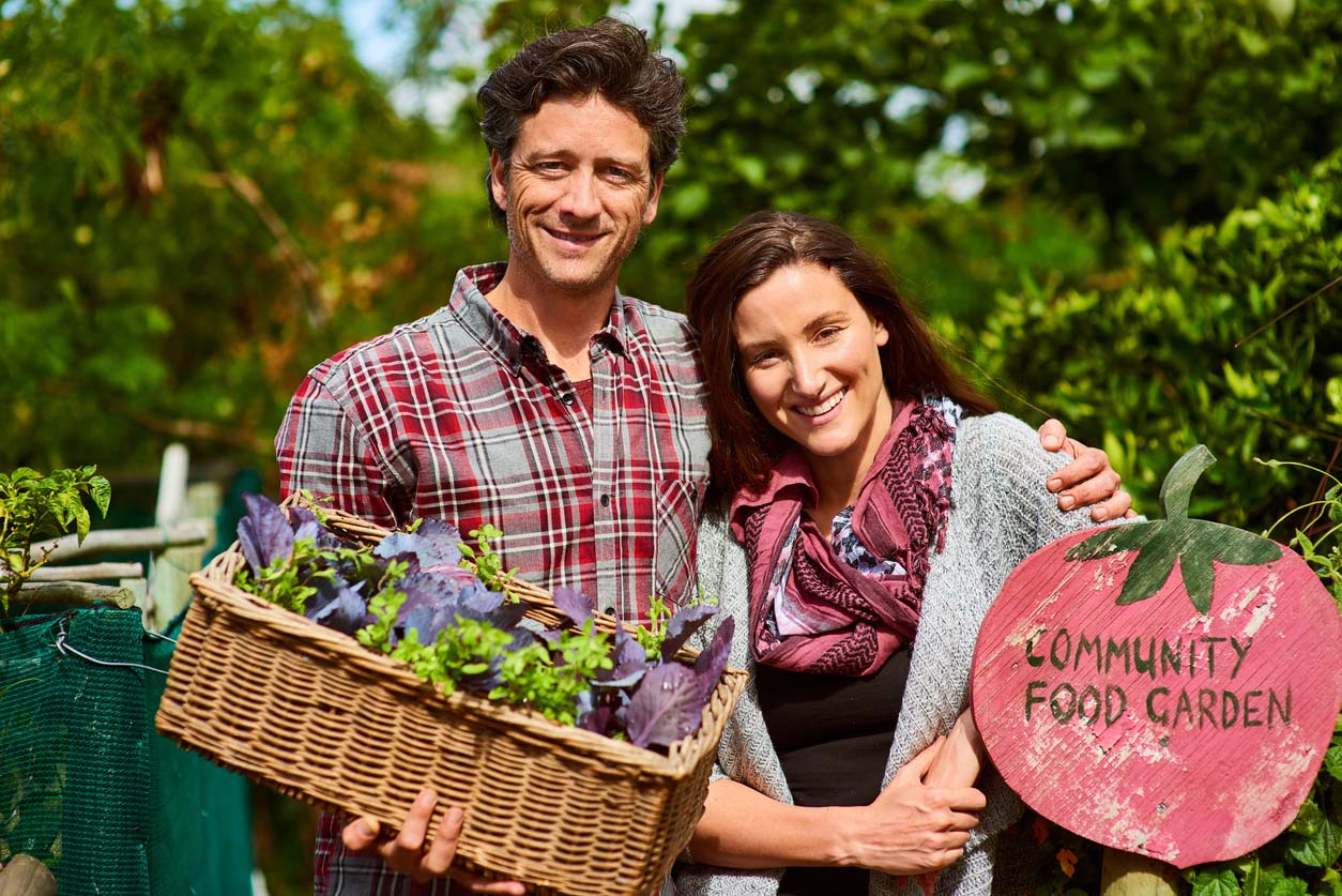 young couple near community garden sign