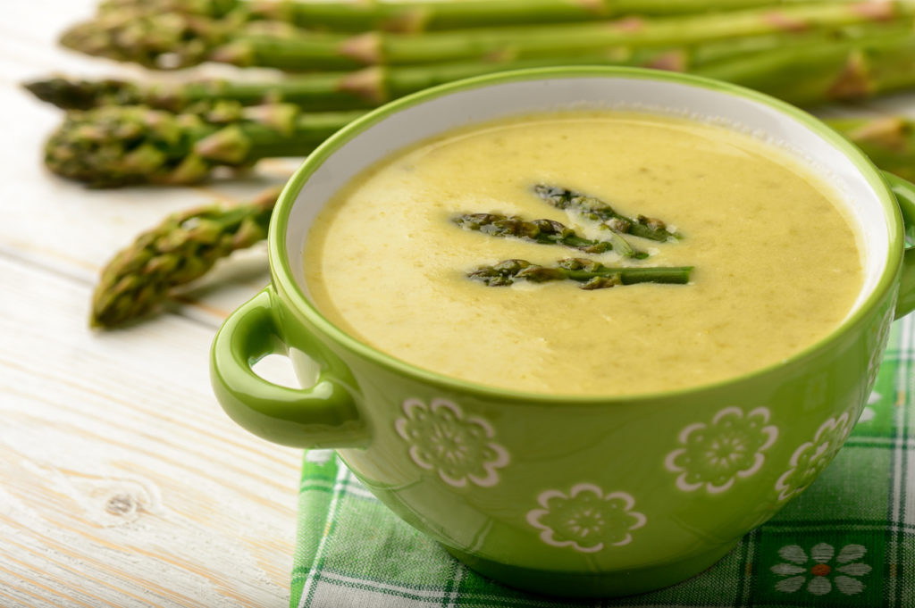 A green bowl of Velvety Asparagus Soup