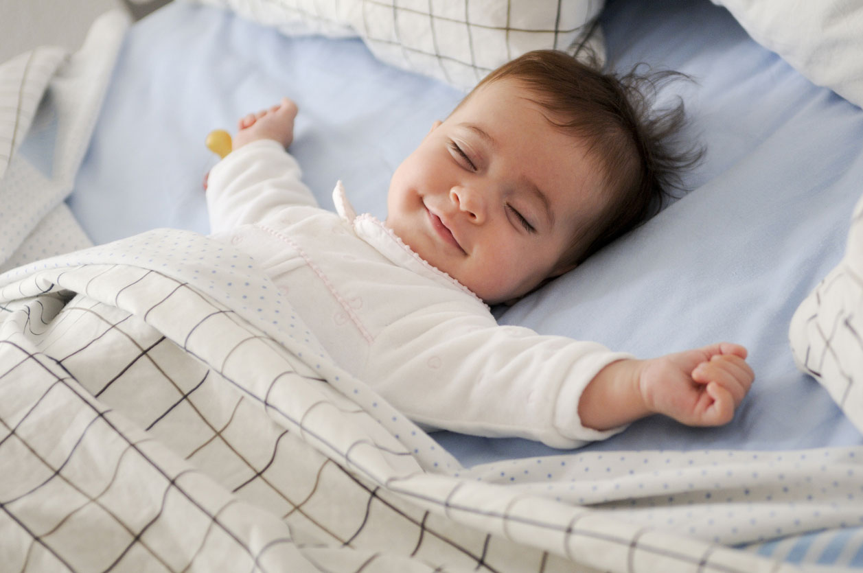 smiling baby girl on bed