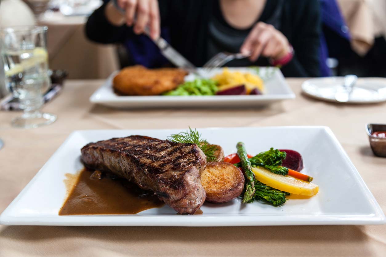 Steak and vegetables on plate in restaurant