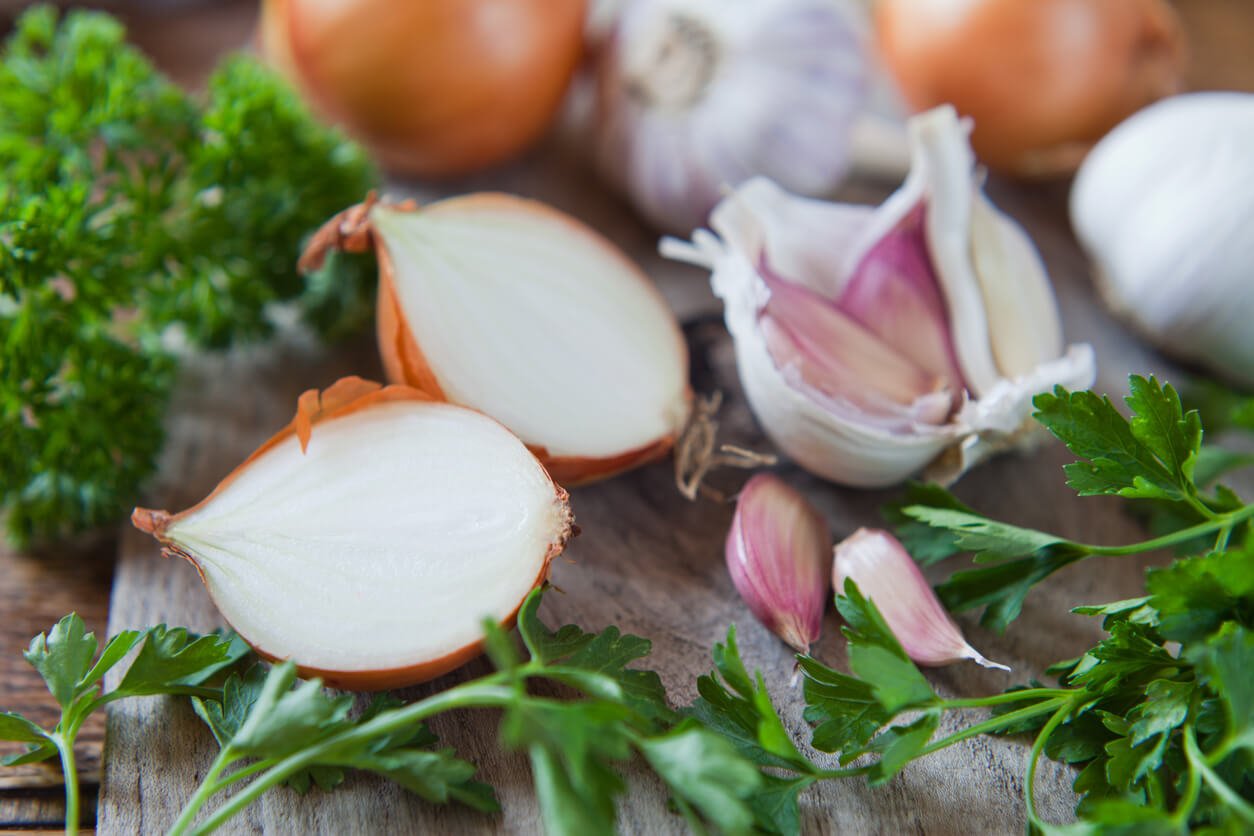 garlic onion and shallots on wooden board 