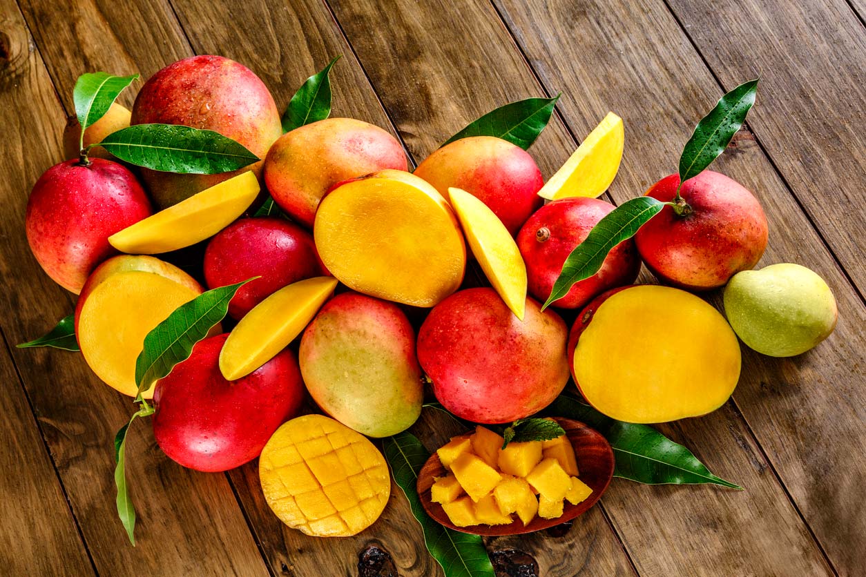 group of ripe mangoes on wooden table