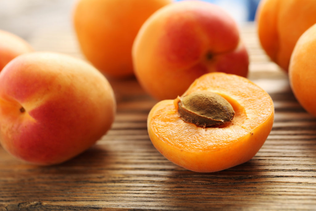 Ripe apricot fruits on wooden table