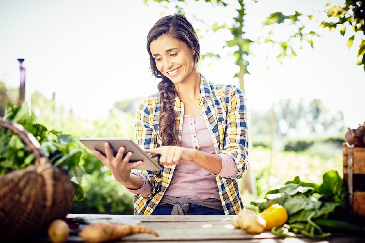 woman looking at planting calendar on tablet while outdoors