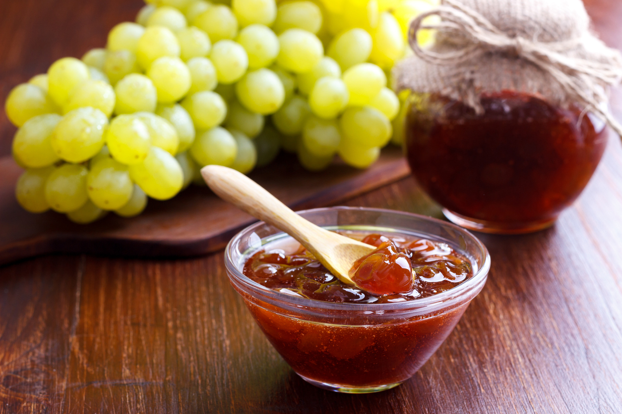 木桌上成熟的葡萄和自制果醬，選擇性聚焦