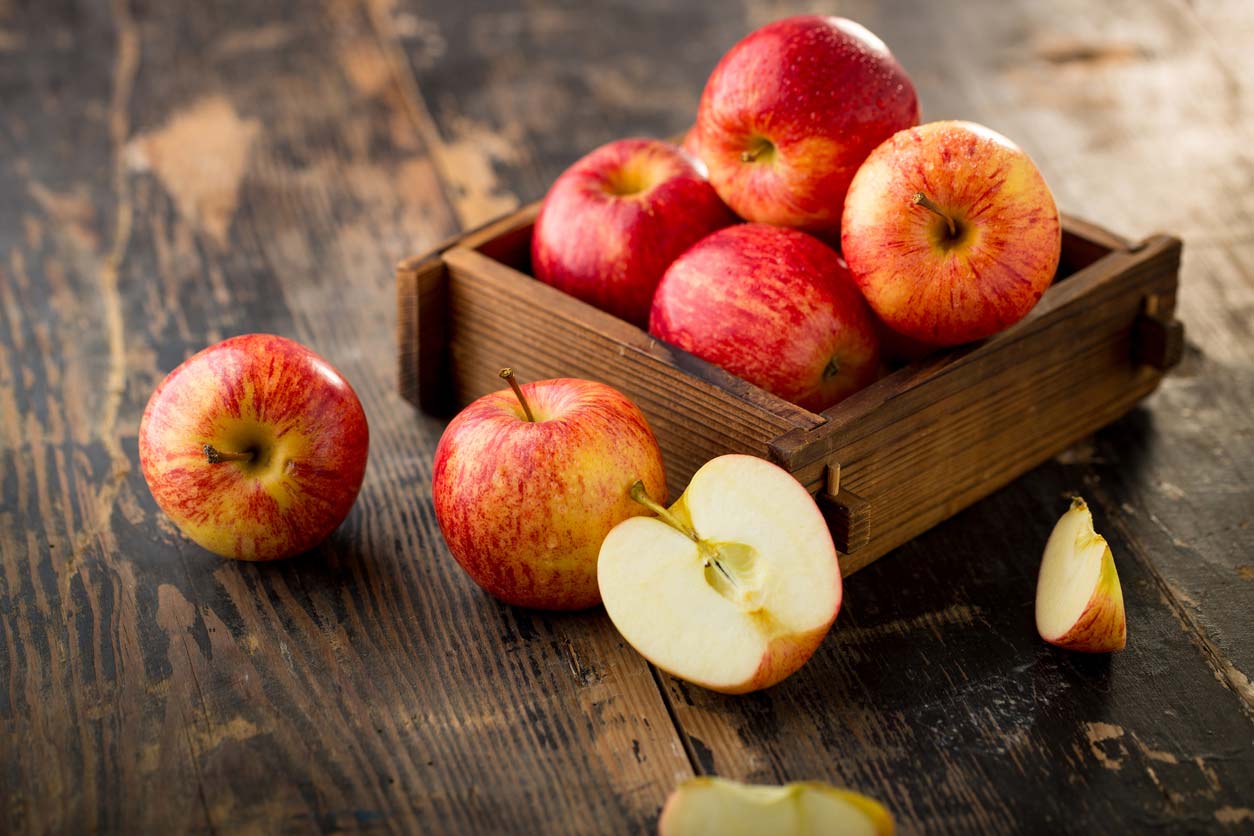 Apples in box on wooden table