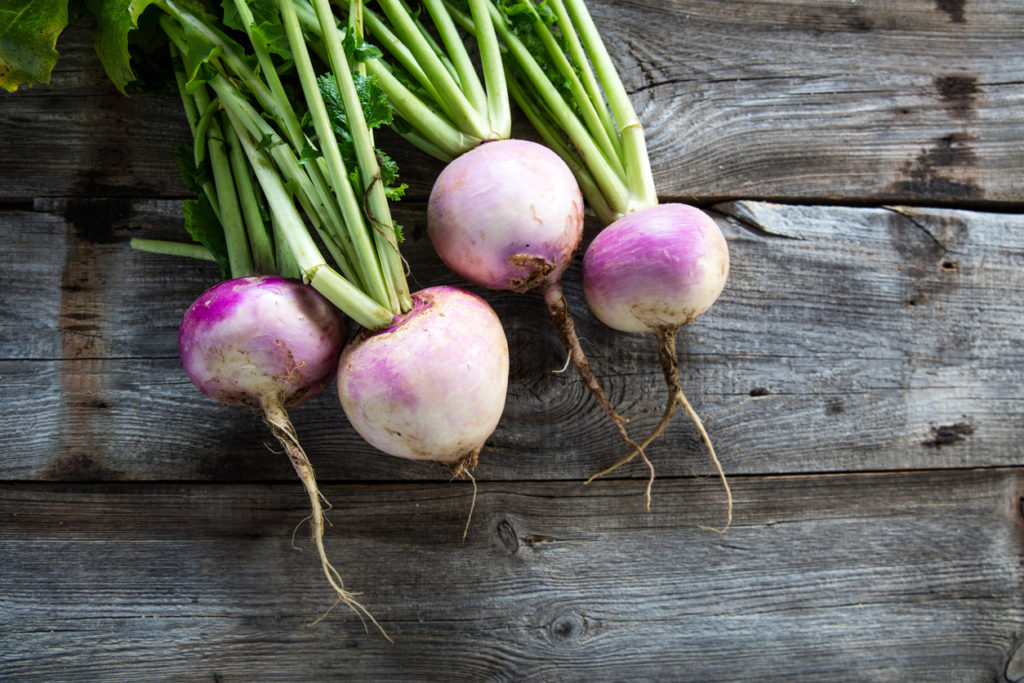 Purple and white turnips with greens still attached