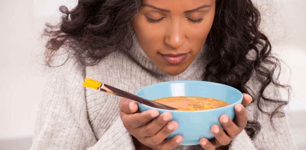 Woman eating a bowl of soup mindfully
