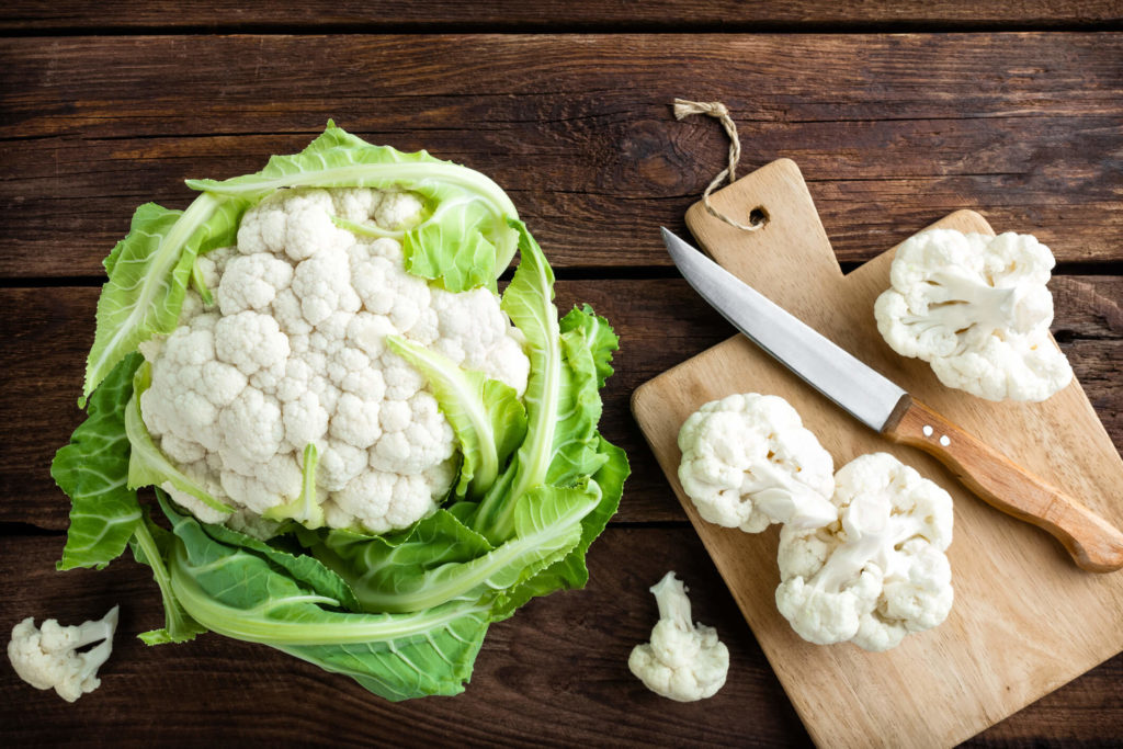 fresh whole cauliflower on wooden rustic background top view