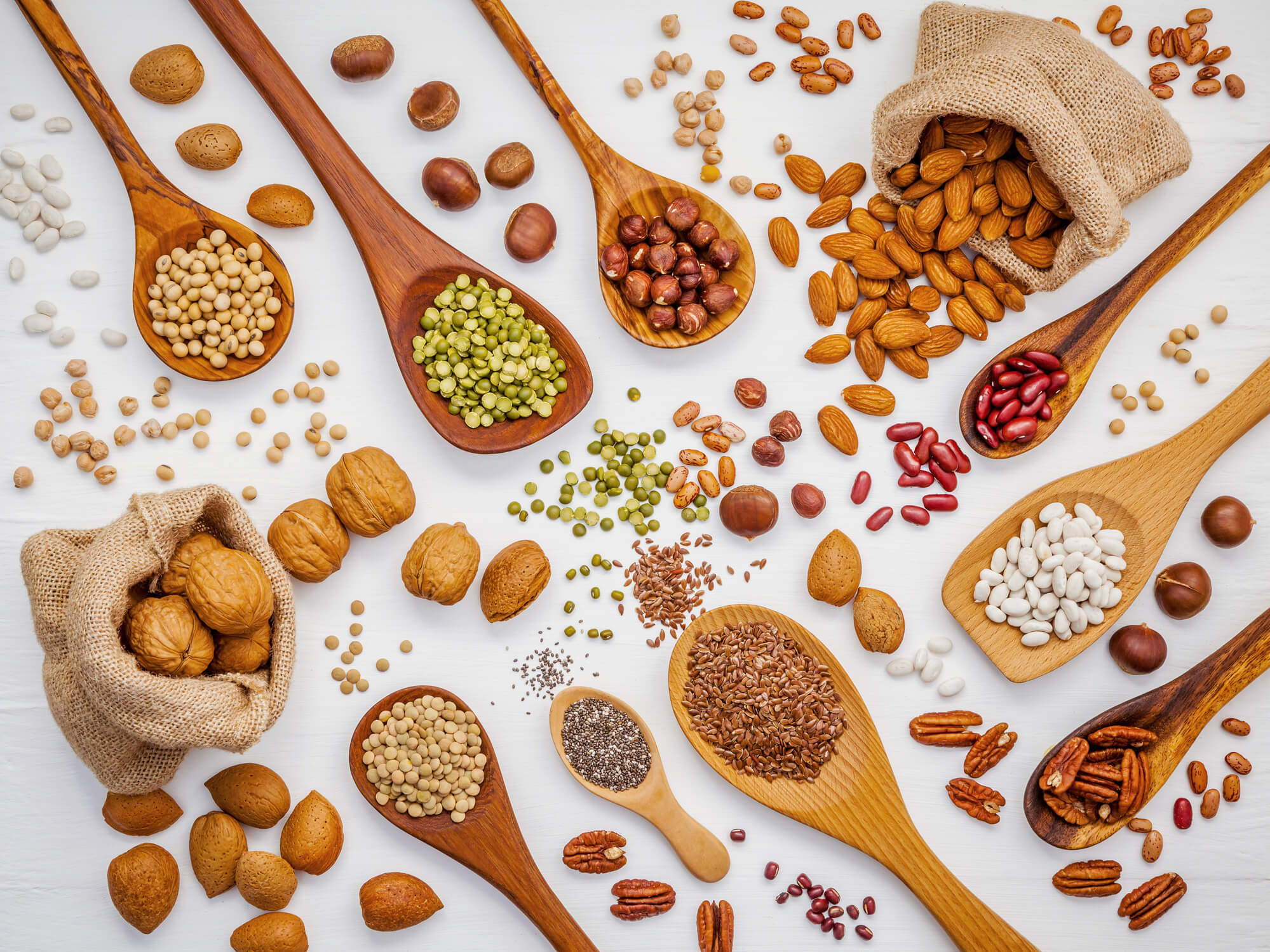 Nuts and seeds in spoons and on a table