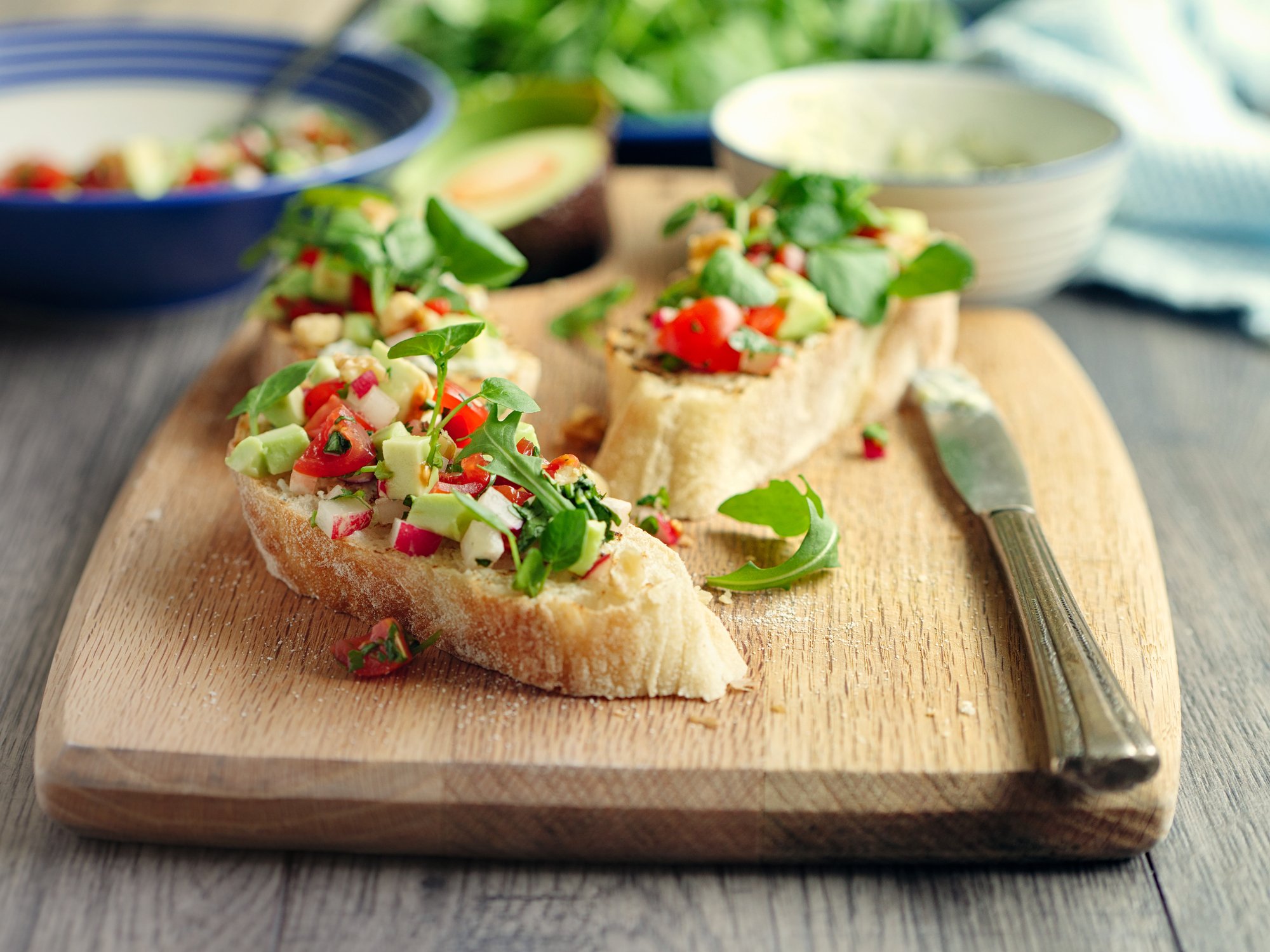 Home made healthy vegetarian bruschetta. Brushing the ciabatta bread with blue cheese sauce,adding on cherry tomato,diced avocado,radish and watercress,walnuts.