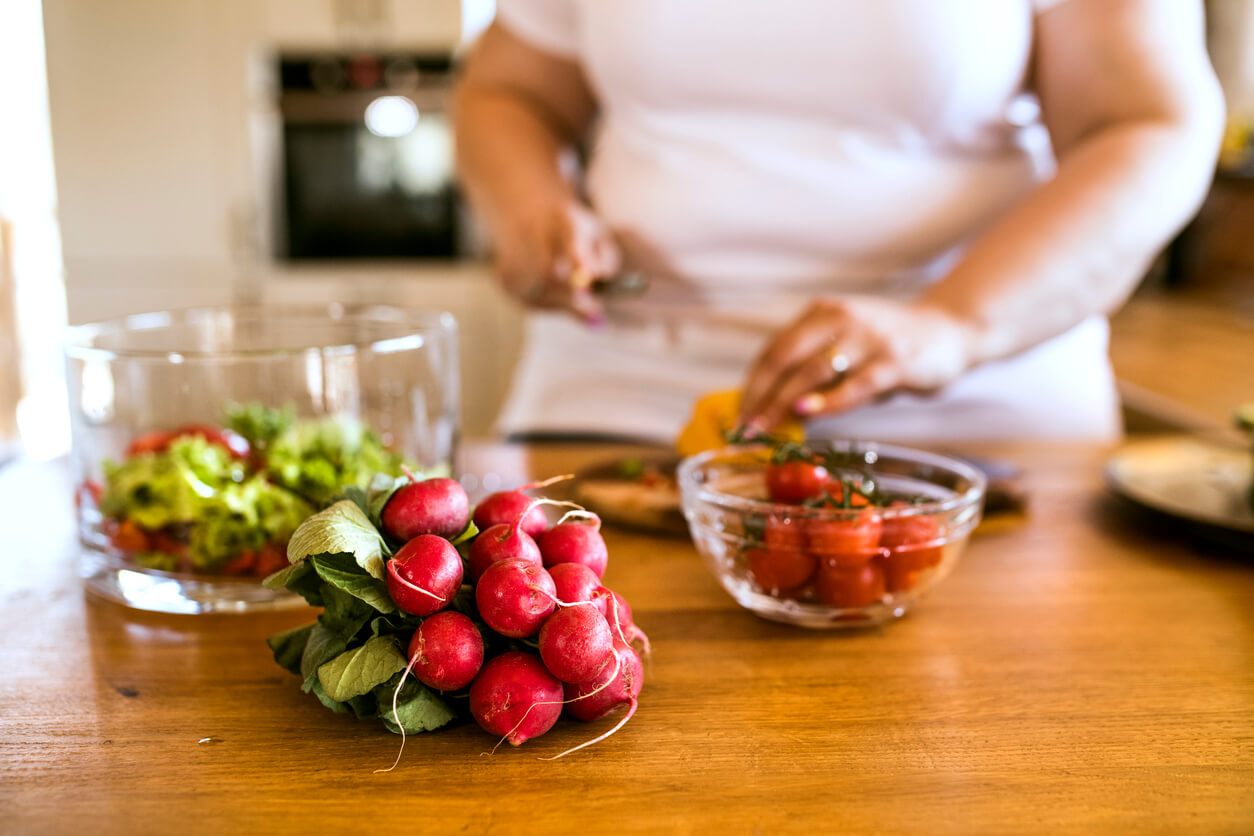 unrecognizable overnight woman at home preparing a delicious healthy vegetable salad