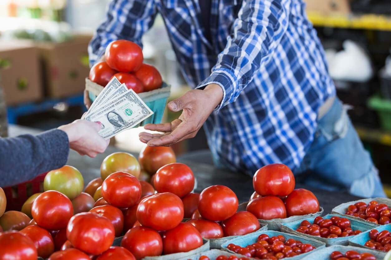 customer paying for tomatoes at produce stand