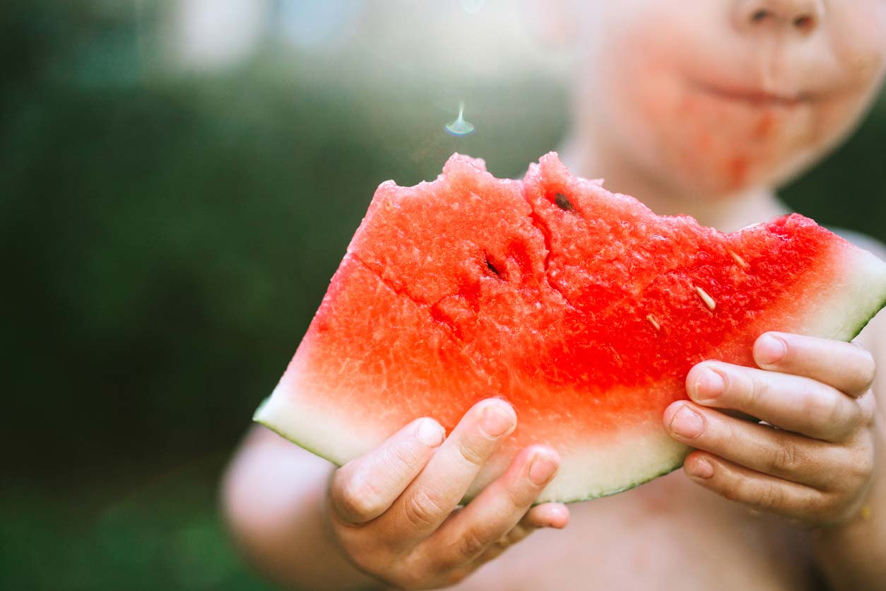 boy eating a slice of watermelon