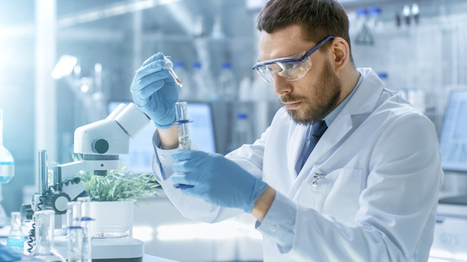 man in lab coat with test tube