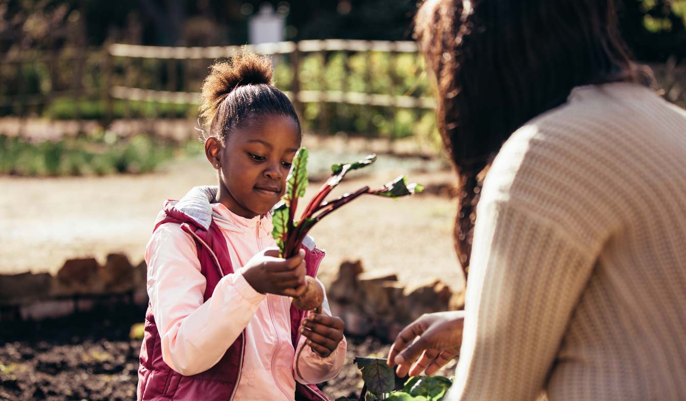 little girl helping mom in garden