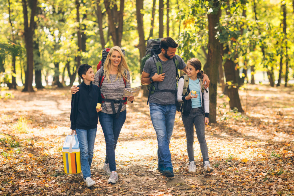 A family hiking in the woods carrying hiking snacks