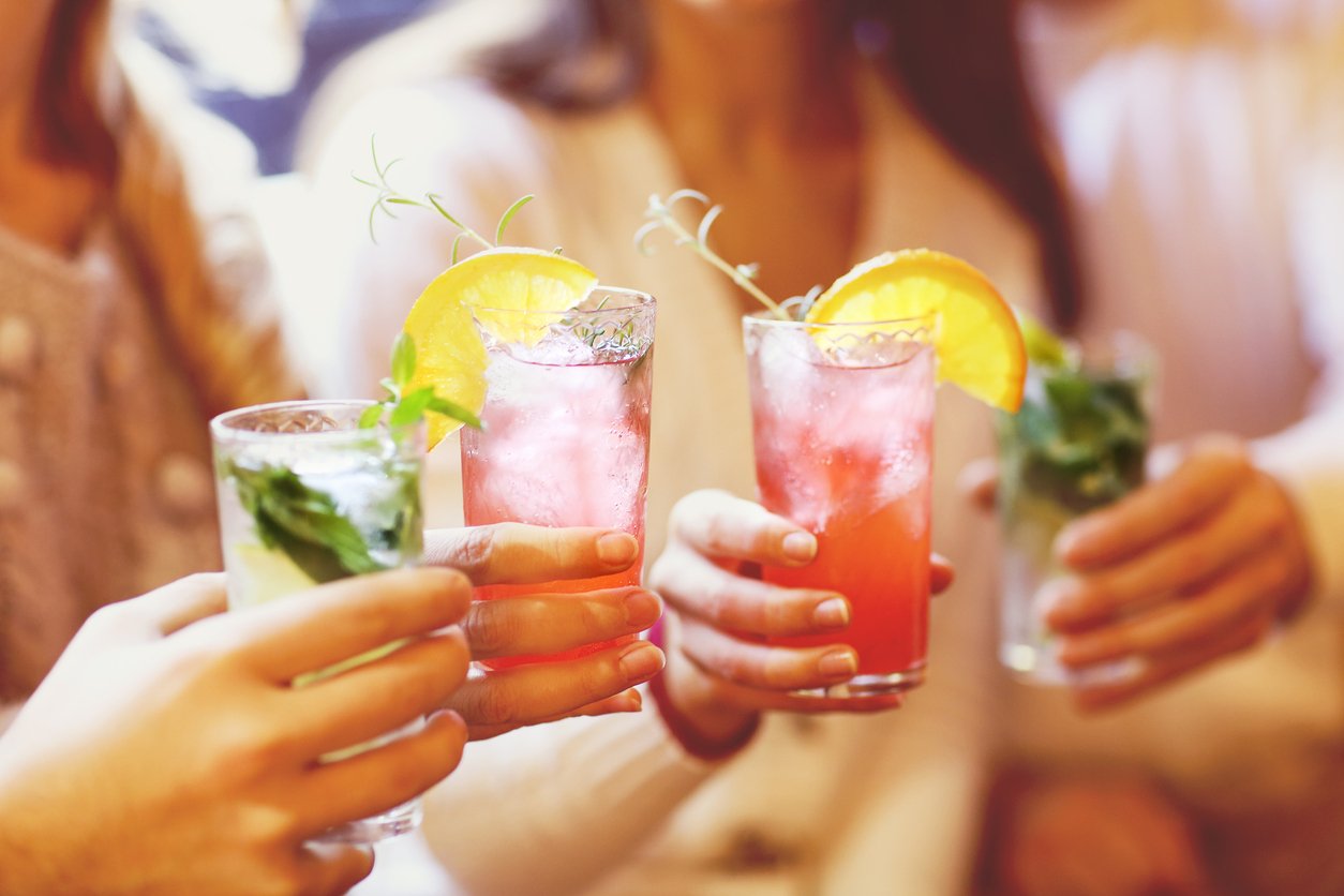 Young men and women drinking cocktail at party