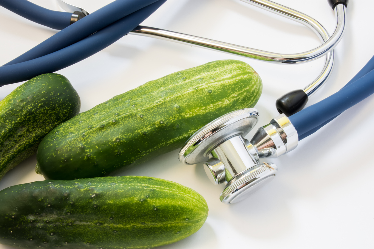 Cucumber and stethoscope. Stethoscope tests three cucumbers for presence of GMO, diseases, varieties. Nutrition and health benefits of cucumber as organic or healthy food for health, use in medicine