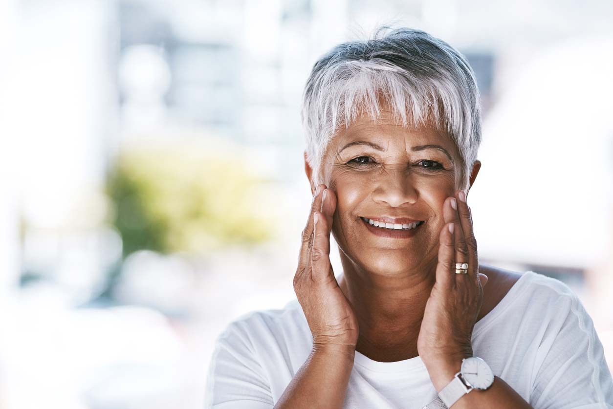 Woman touching cheekbones with clear skin