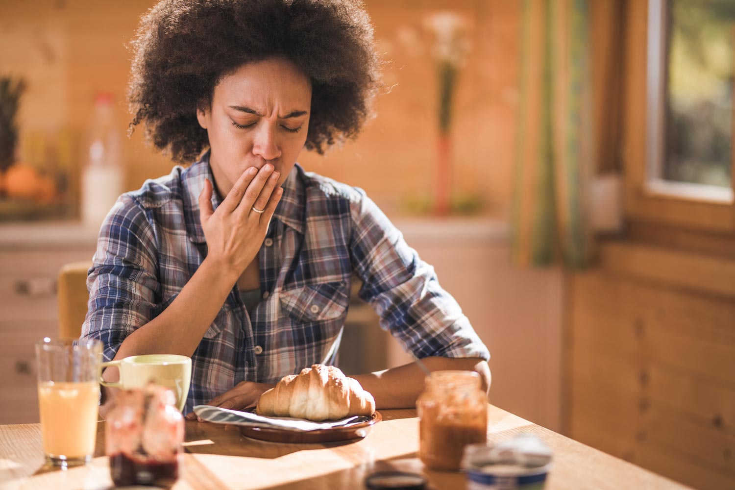 woman showing signs of nausea during breakfast wondering are grains good for you?